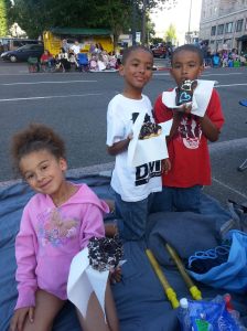 Adrian, Xavier and Davonni holding up their doughnuts. 